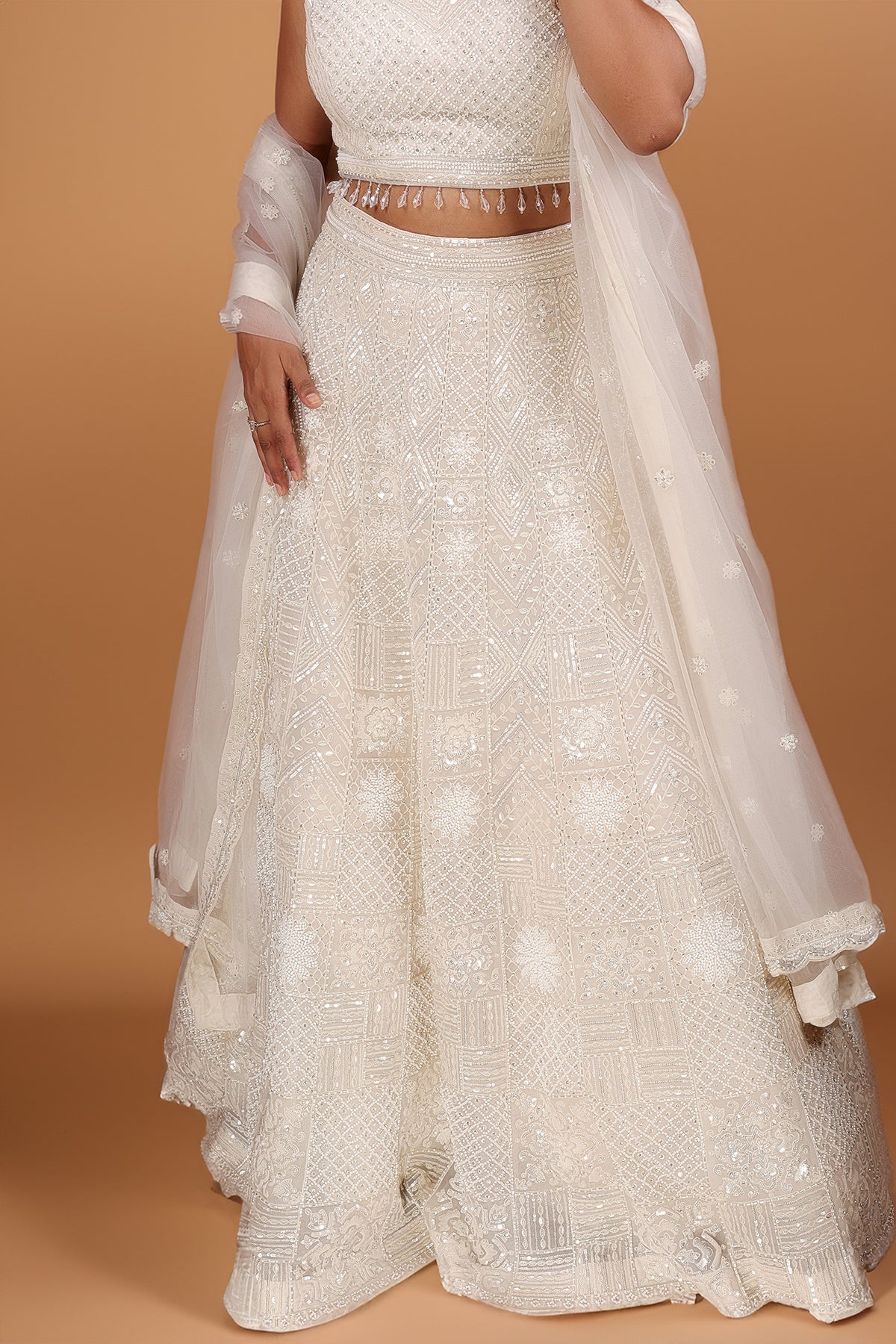 White Lehenga in Net fabric adorned with thread, pearl and cut dana embroidery