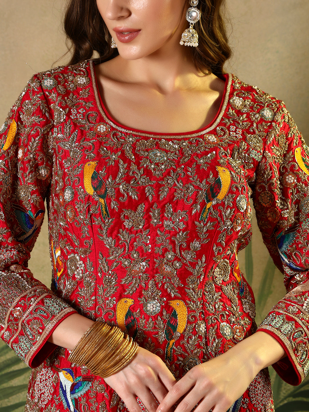 Vibrant red suit, adorned with intricate bird and floral embroidery