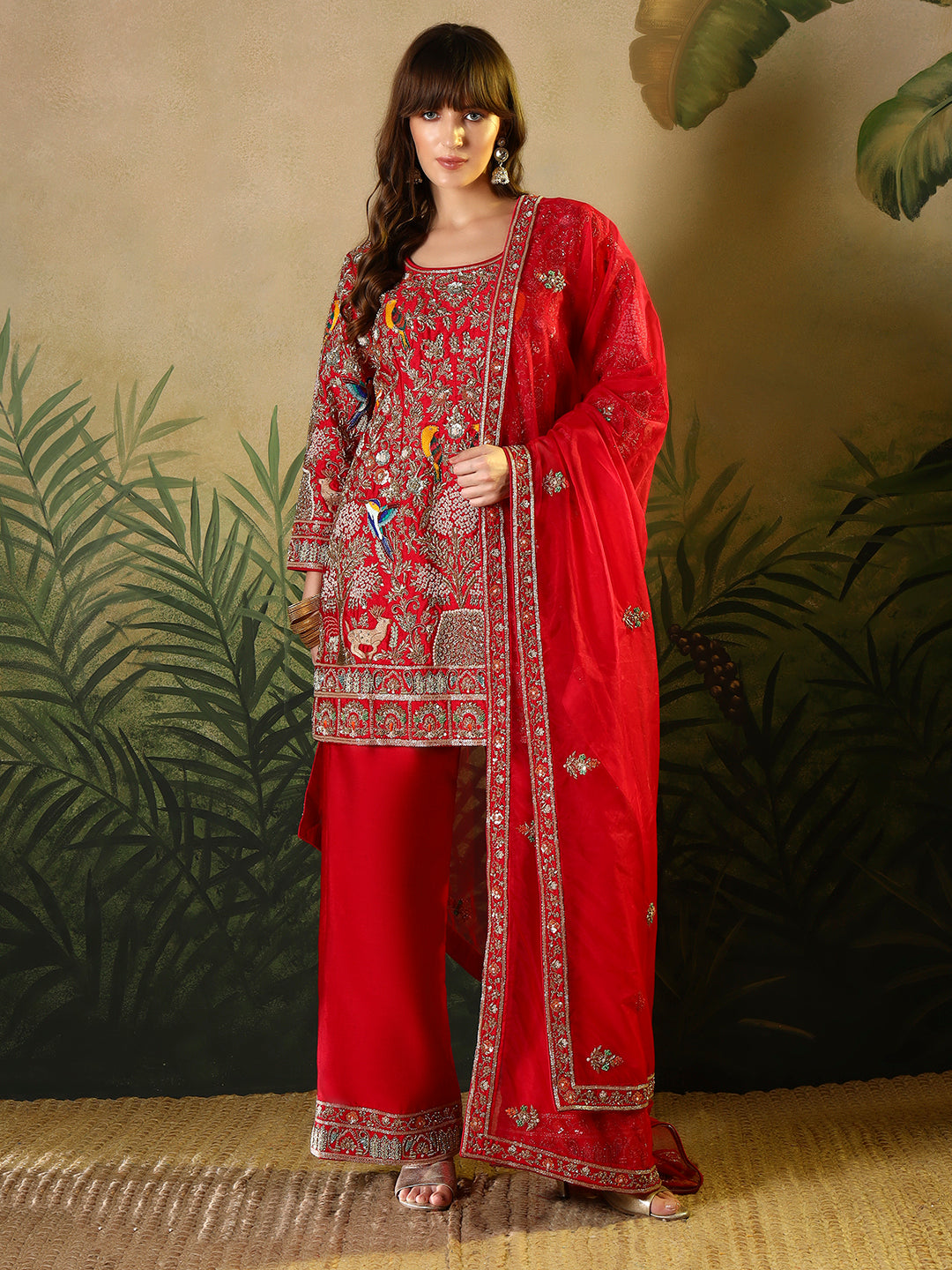 Vibrant red suit, adorned with intricate bird and floral embroidery