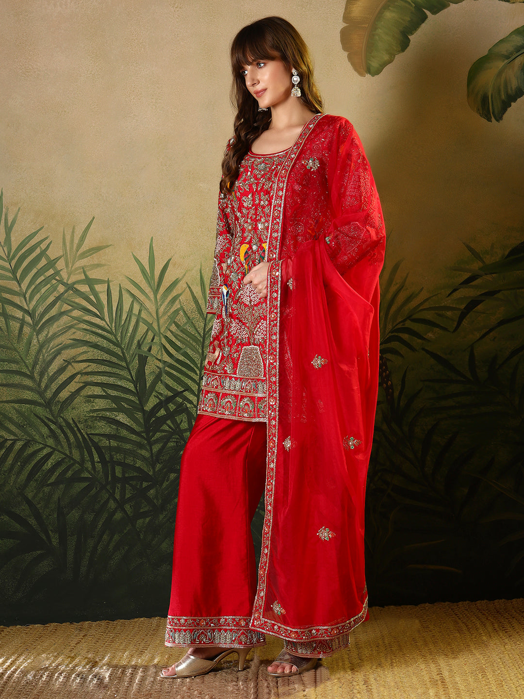 Vibrant red suit, adorned with intricate bird and floral embroidery