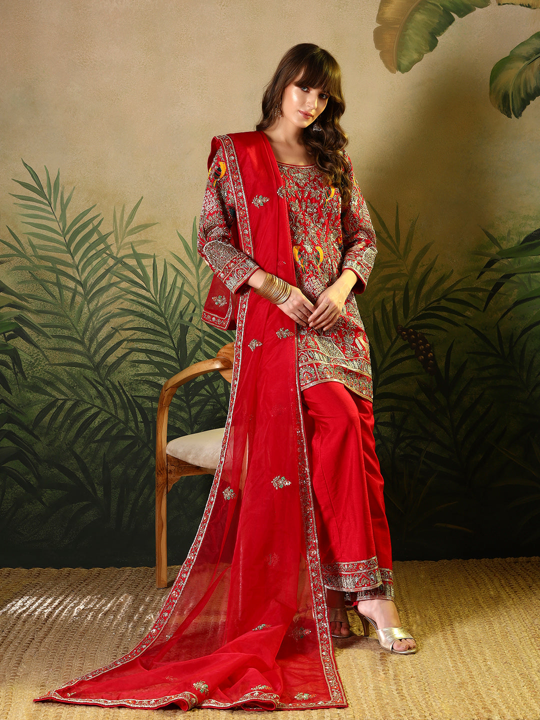 Vibrant red suit, adorned with intricate bird and floral embroidery
