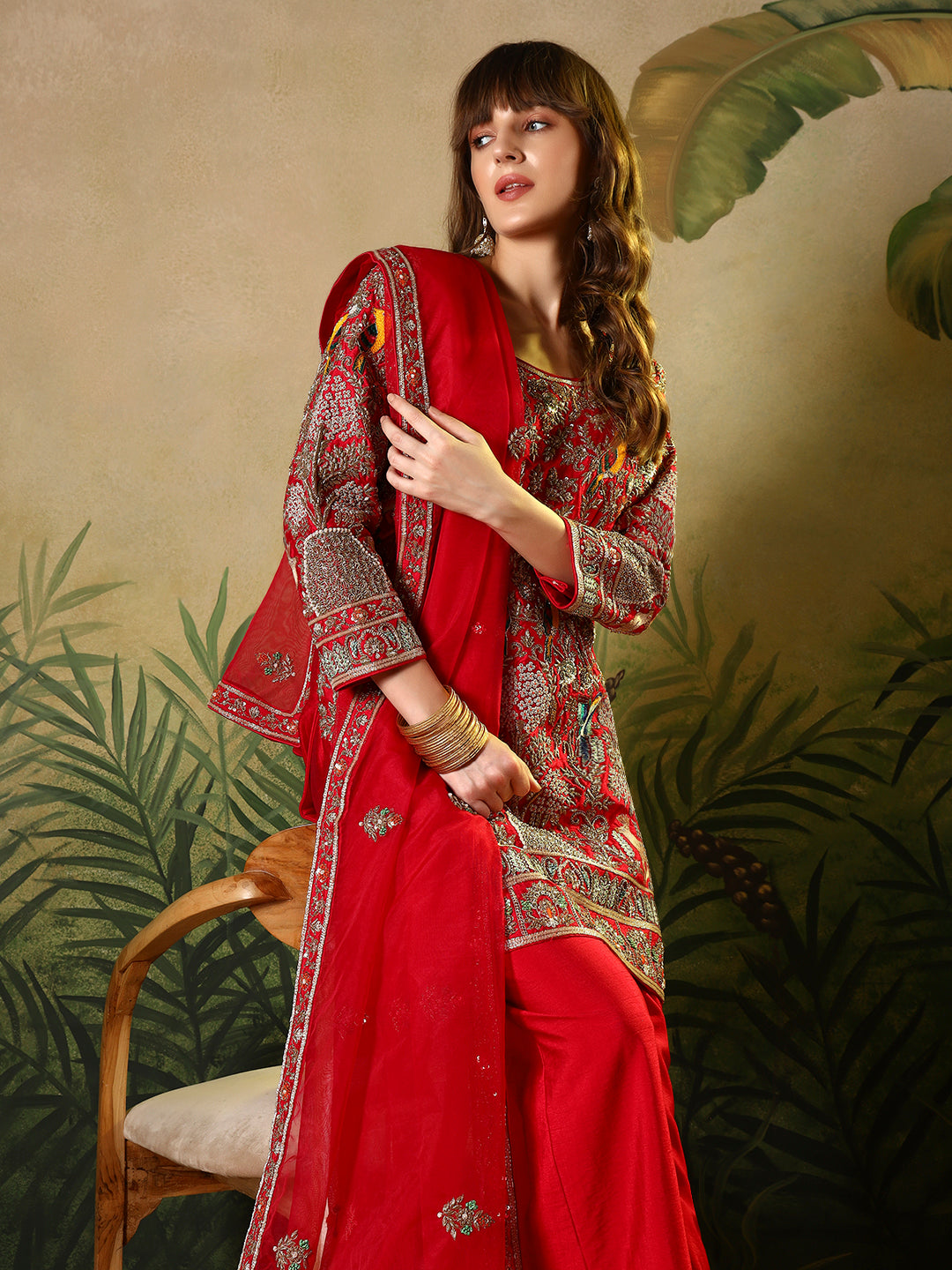 Vibrant red suit, adorned with intricate bird and floral embroidery